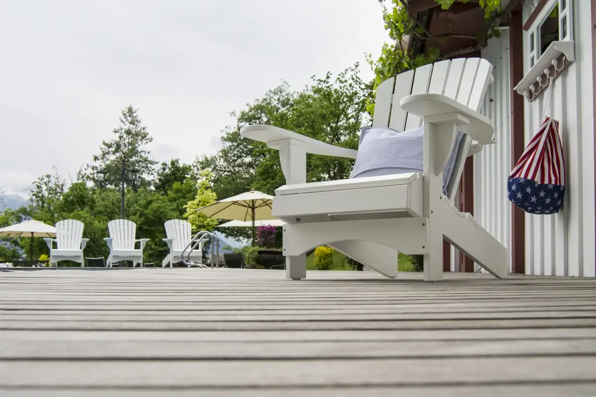 weisser-adirondack-stuhl-holzterrasse-kissen.webp